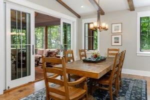 Large dining table by screened deck entrance with french doors