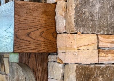 Closeup of stone fireplace with wood mantle