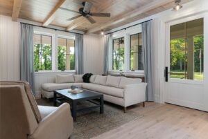 Remodeled energy-efficient living room in luxury home near Asheville, NC, featuring original farmhouse aspects, locally milled wood, exposed beams, and natural elements.
