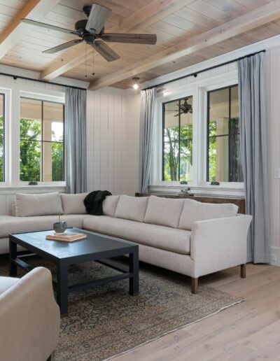 Remodeled energy-efficient living room in luxury home near Asheville, NC, featuring original farmhouse aspects, locally milled wood, exposed beams, and natural elements.