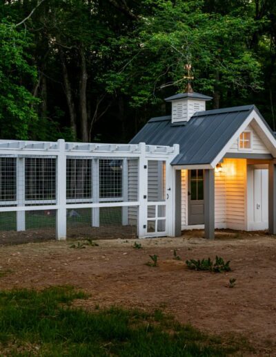 Remodeled house with cute chicken coop in front, energy-efficient, luxury home builder in Asheville, NC, featuring original farmhouse aspects, locally milled wood, exposed beams, and natural elements.